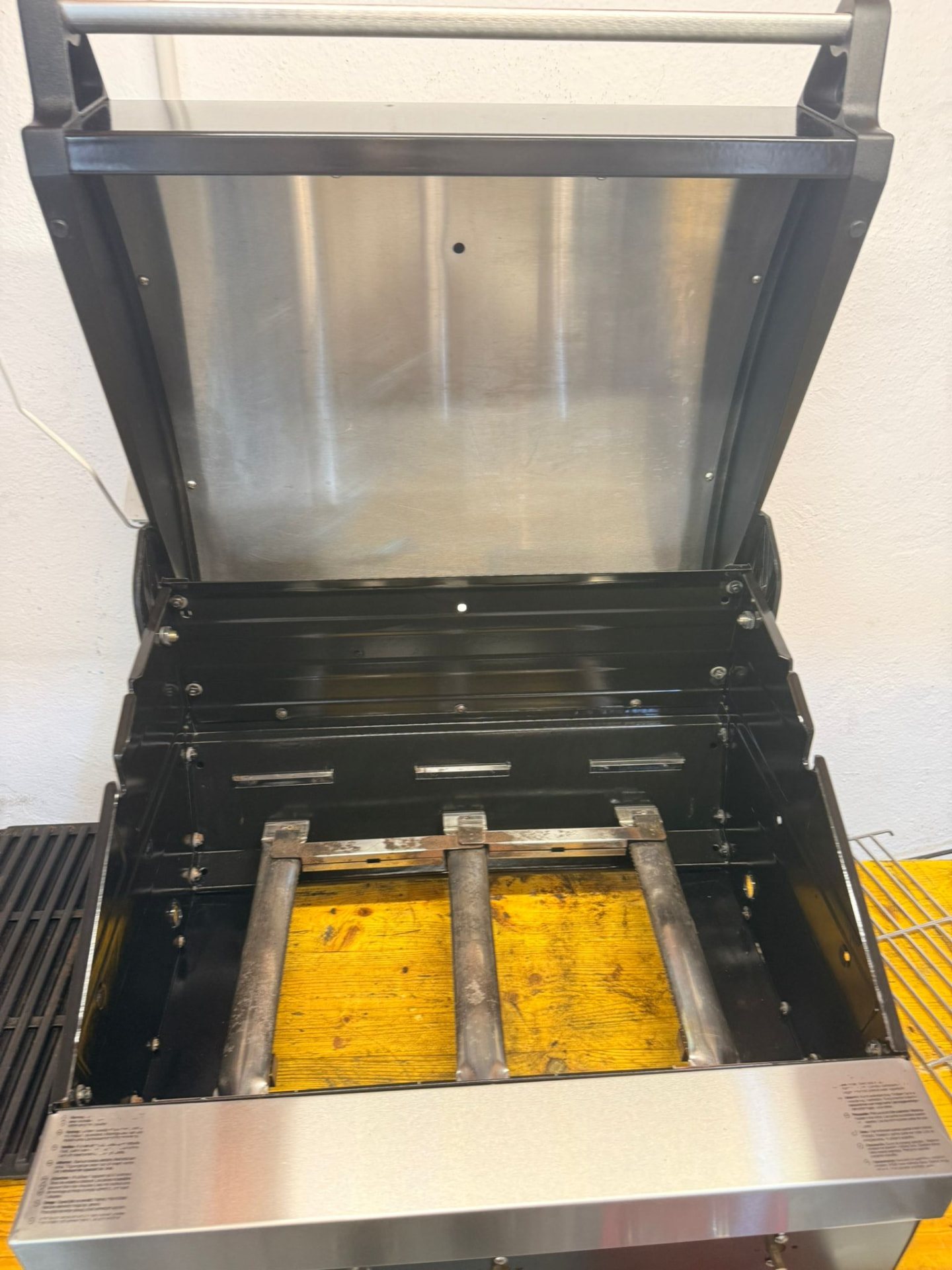 Grill under remontering i verkstedet med rister fjernet til sidene.