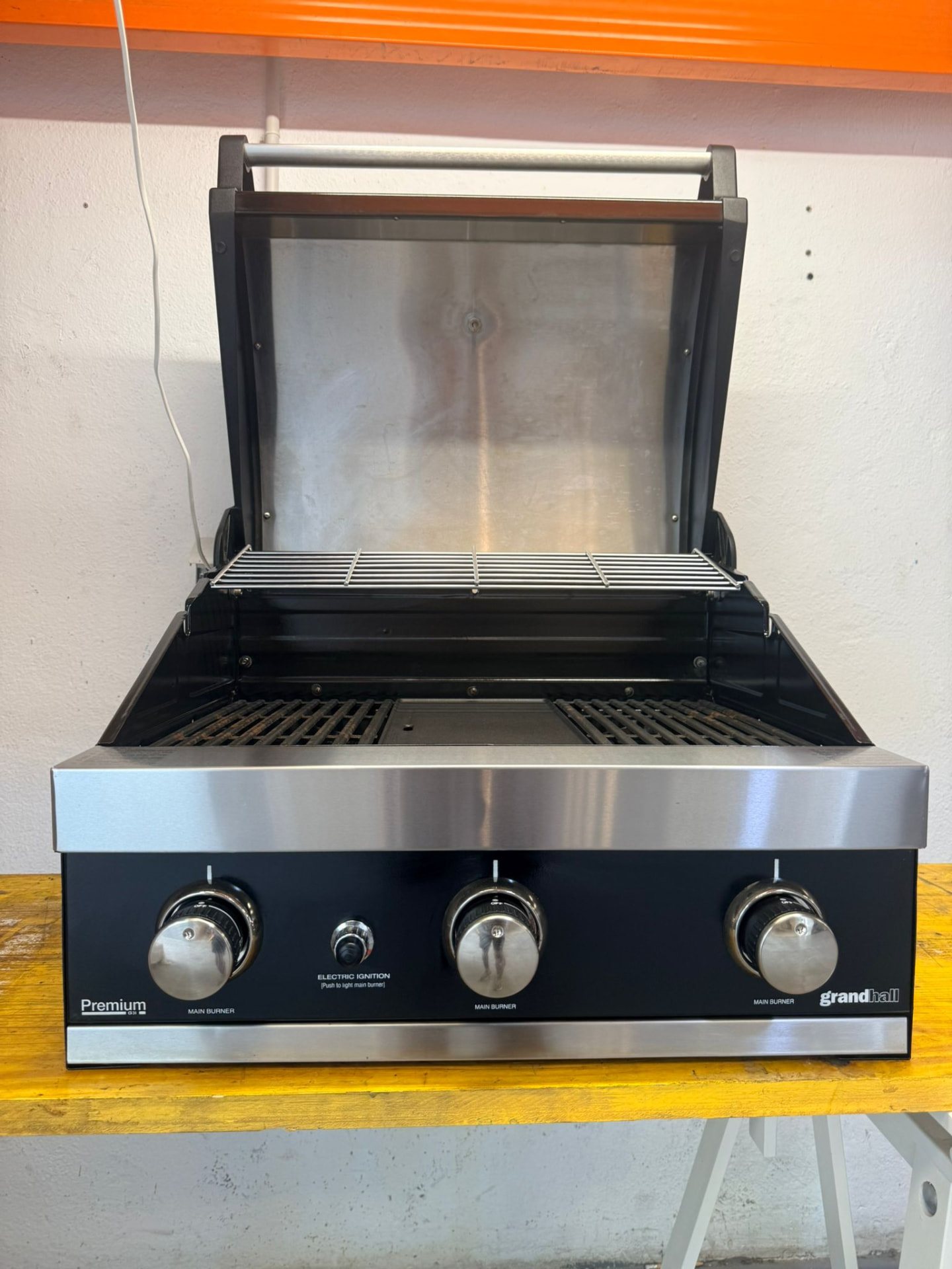 Grill sett forfra, montert i verkstedet med åpent lokk.
